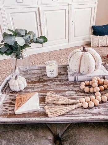 a reviewer's tray set up with white pumpkins around the candle