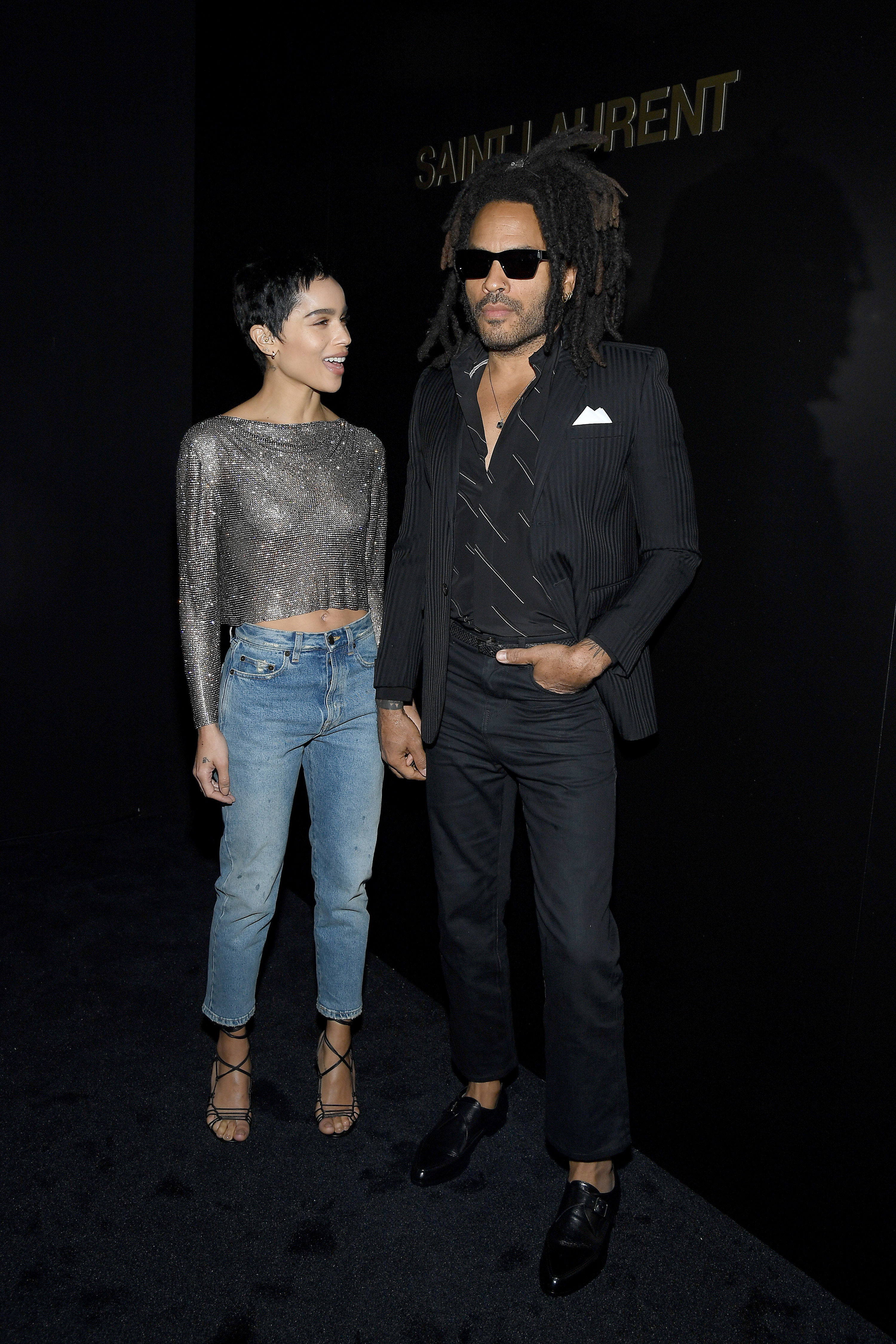 Zoe and Lenny Kravitz pose, she wears jeans a sparkling top strappy heels