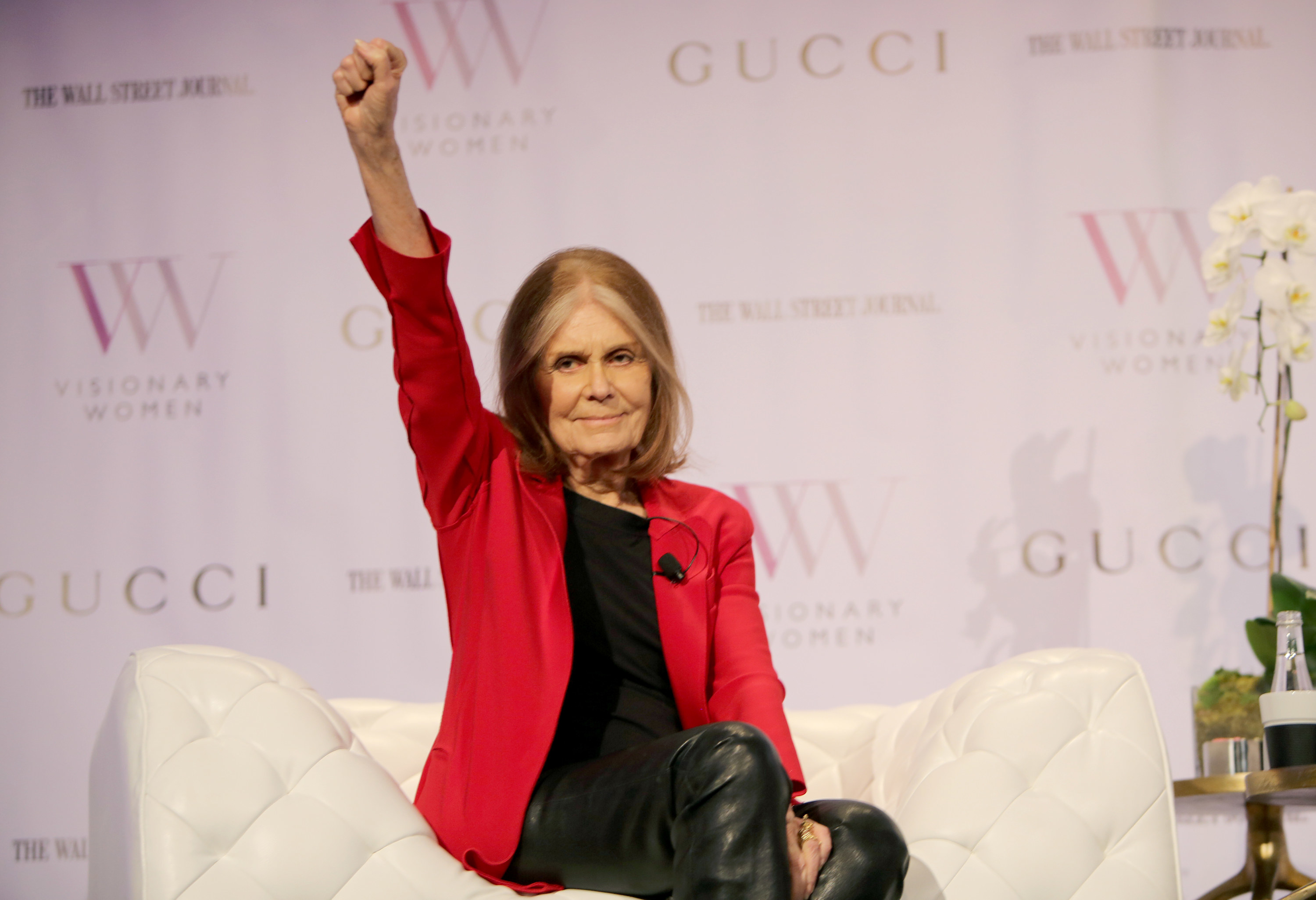 Gloria holding her fist up as she sits during an interview