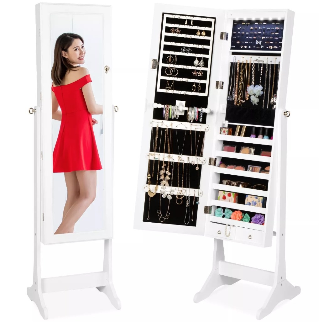 A model looking into a full length armoire mirror that holds jewelry