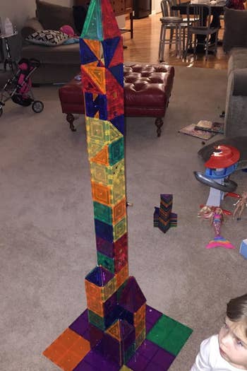 Reviewer's showing their child's creation made with the magnetic multicolored tiles