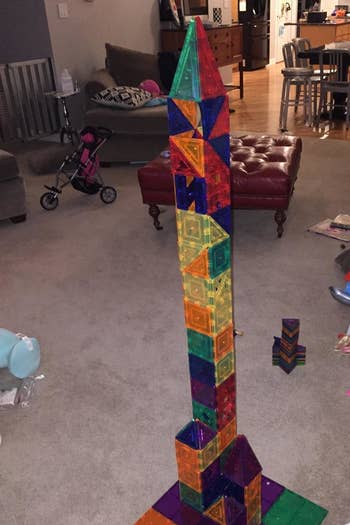 Reviewer's showing their child's creation made with the magnetic multicolored tiles