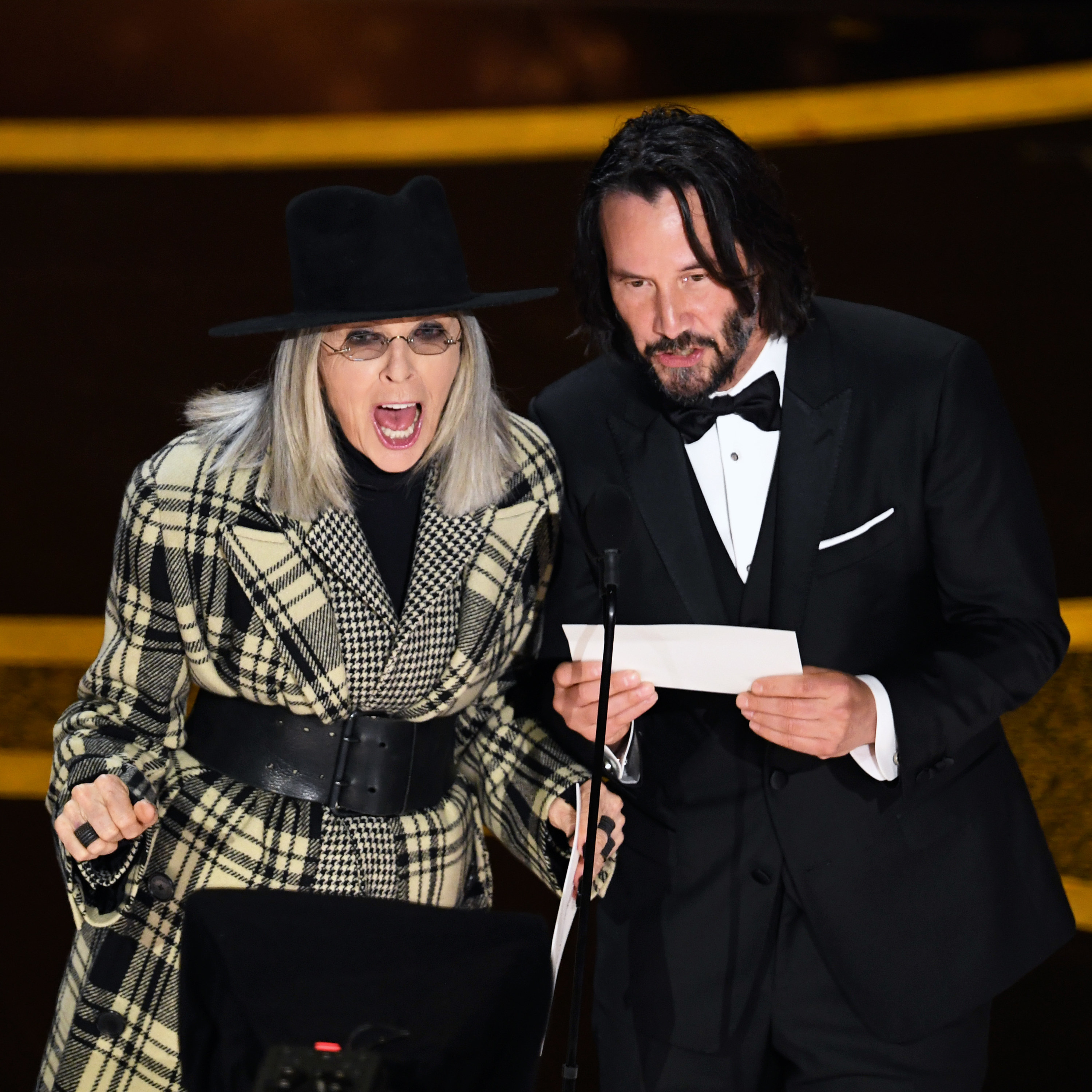 Diana and Keanu Reeves presenting an award on stage