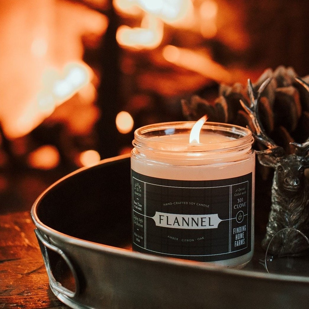 a white candle with a gray flannel printed label on it