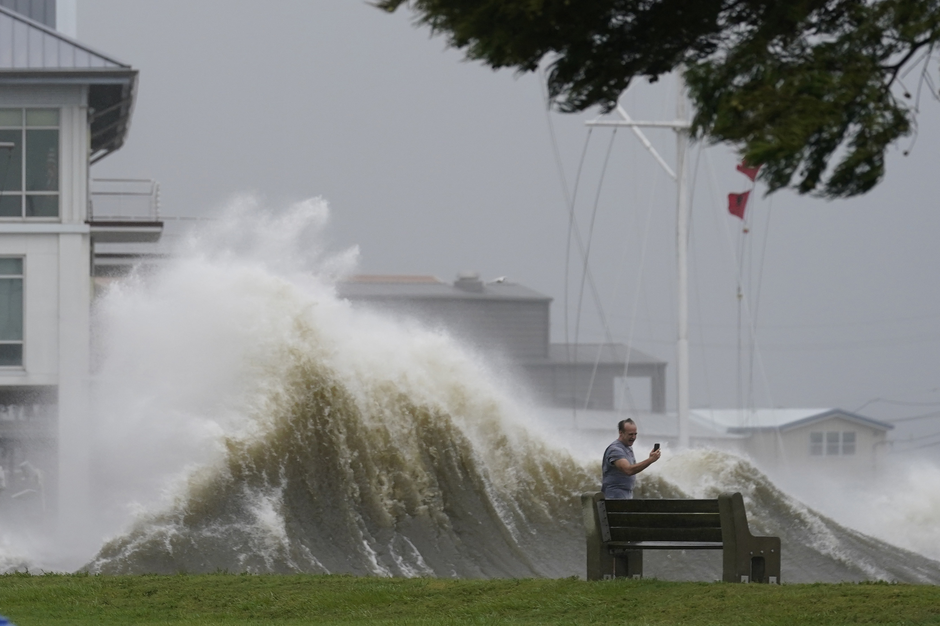 A man takes a selfie with a massive storm well wave behind him