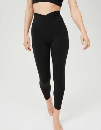 Model in a pair of black leggings with the waist cut like a V 