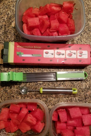 a reviewer photo of the slicer surrounded by containers filled with cubed watermelon 