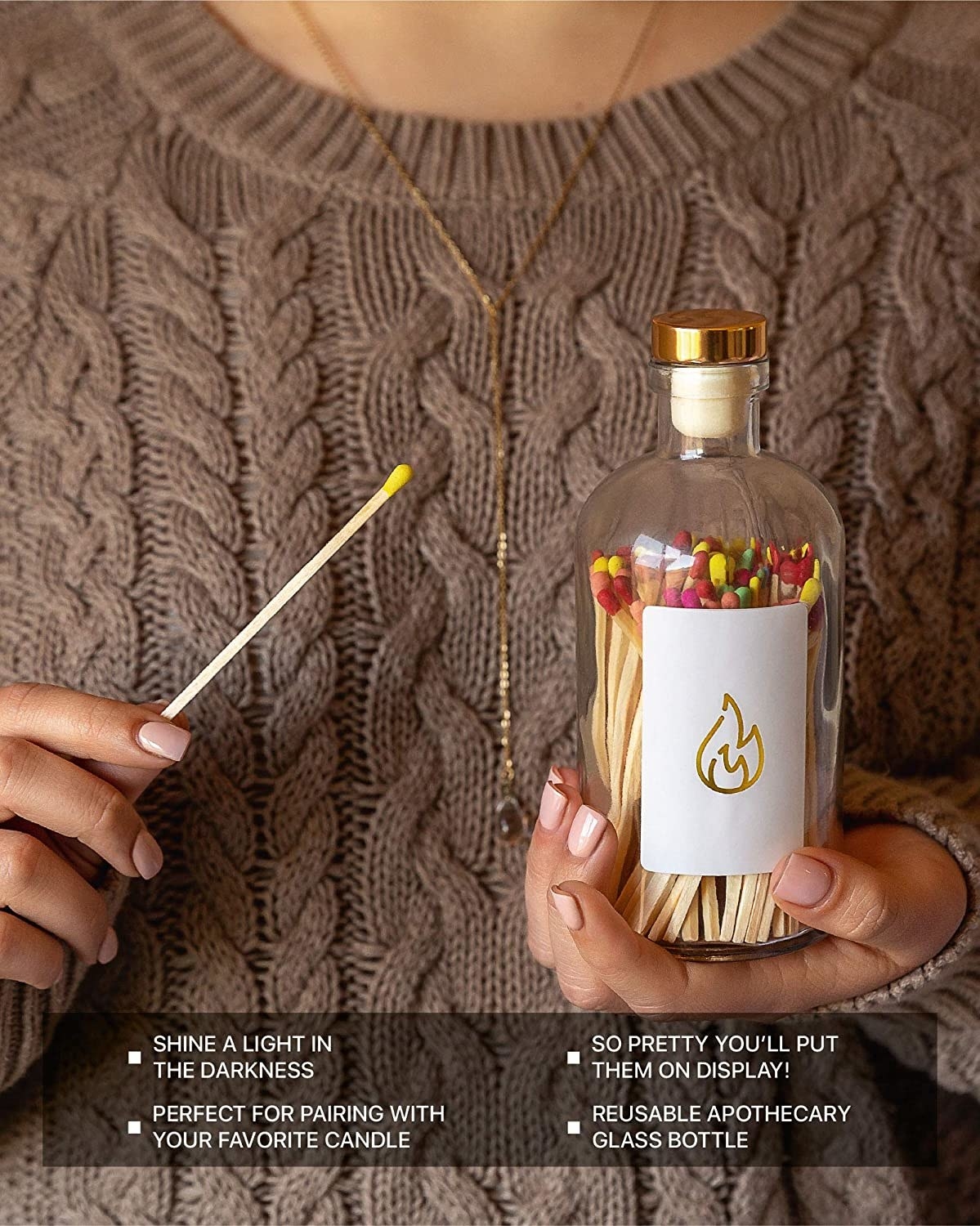 model holding the jar of matches as well as one long, unlit match in their other hand