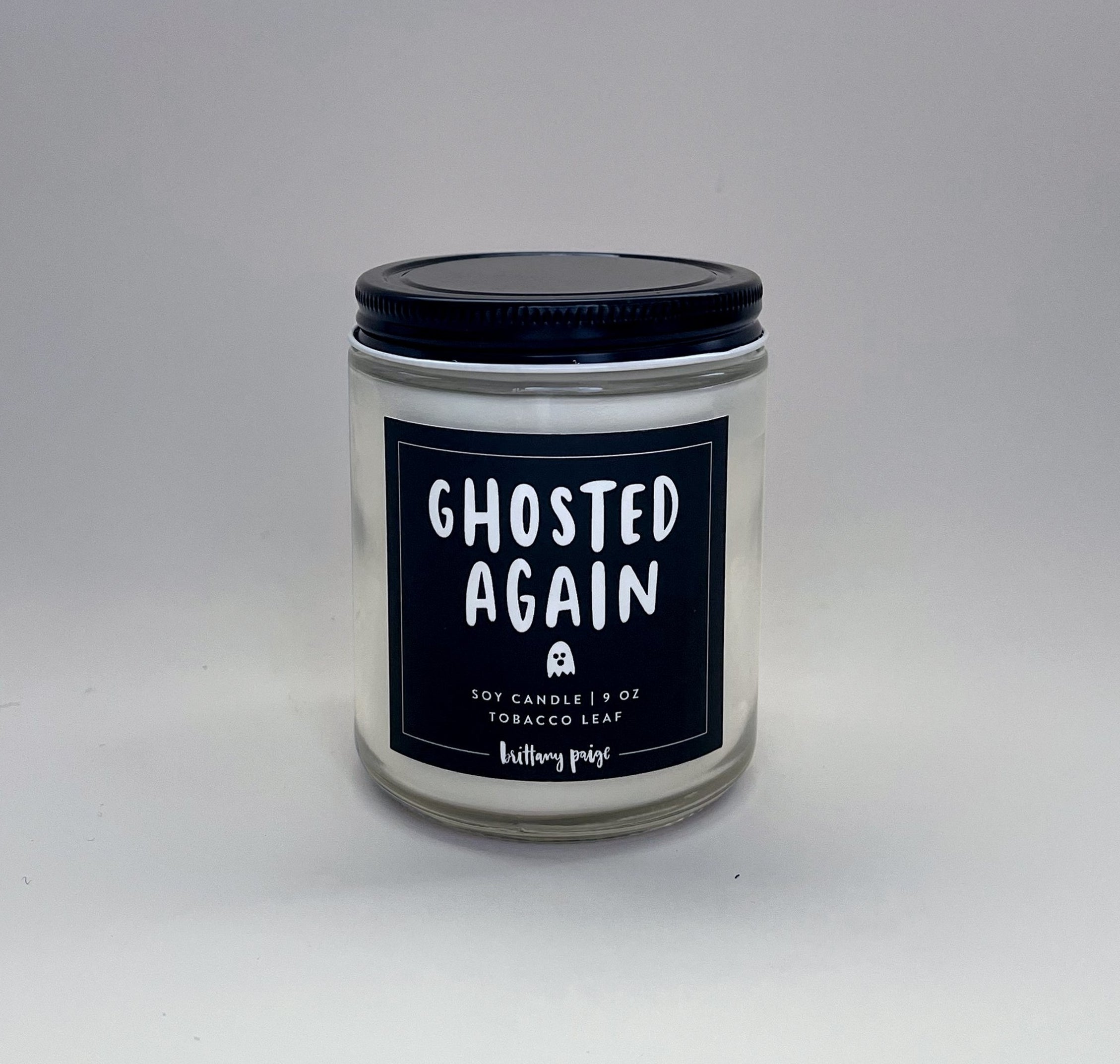 a candle with a black label on it that says ghosted again