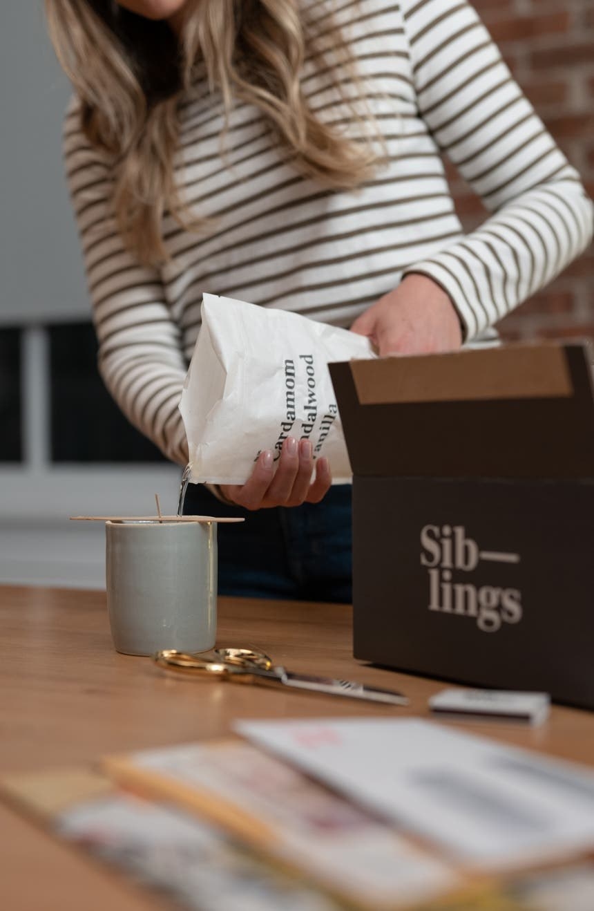 person pouring wax into a container