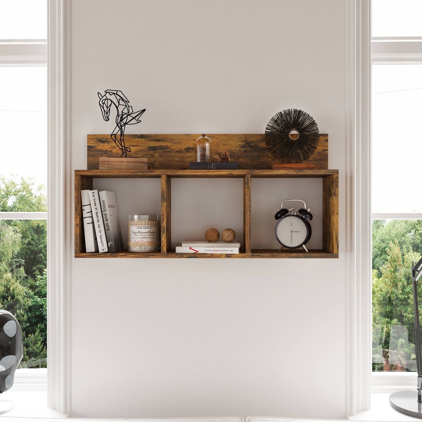 The rustic triple cubby shelf in the color aged wood hanging above a couch