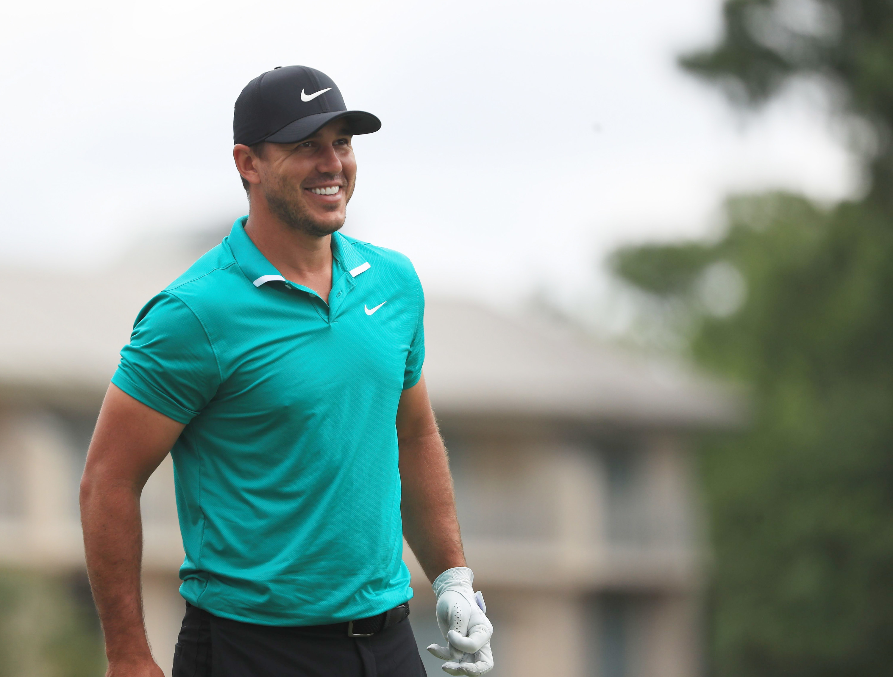 Brooks Koepka smiles in golf attire