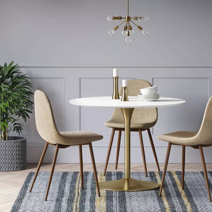The dining table with a gold base and white top