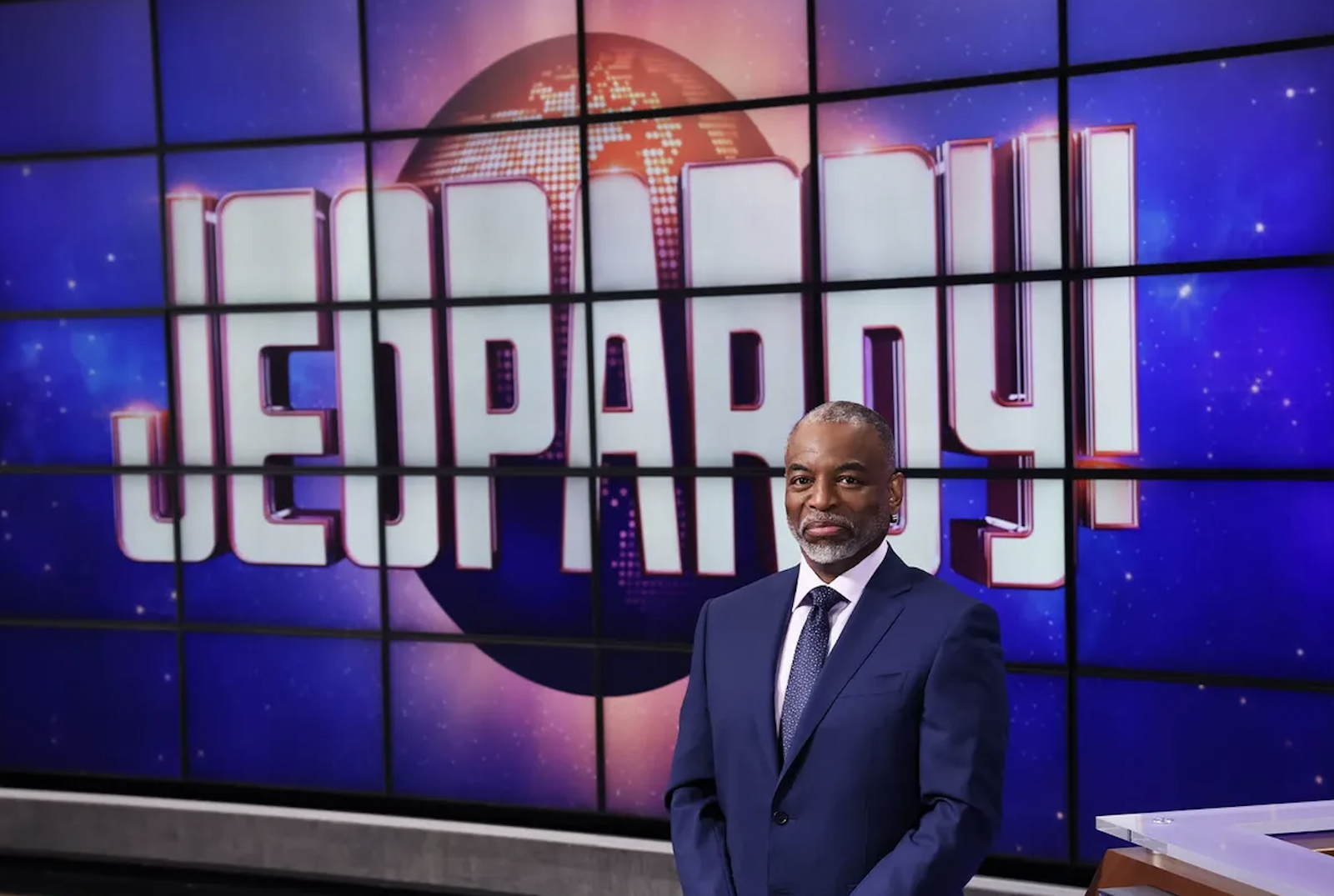 LeVar Burton standing in front of the Jeopardy! screens