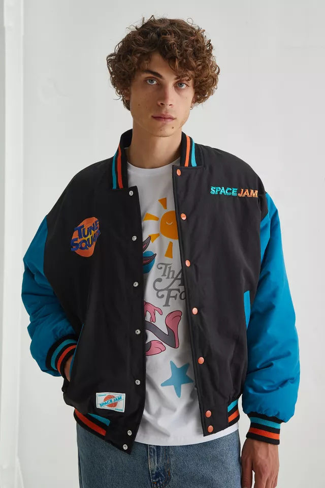 A person wearing a bomber jacket with a T-shirt and jeans