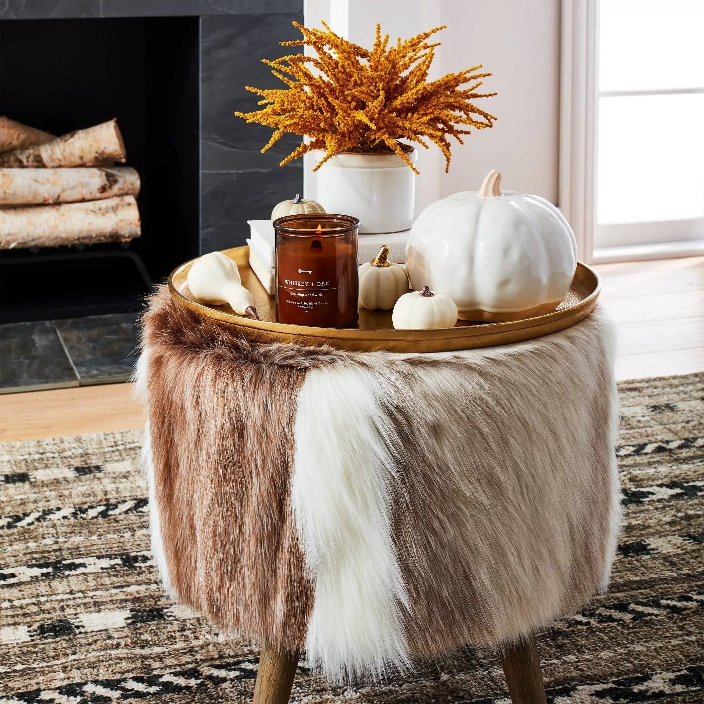 The faux fur ottoman functioning as a small table in a living room