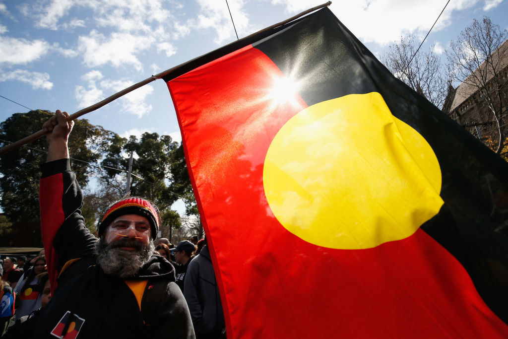 An Aboriginal flag is held aloft during a Black Lives Matter protest to express solidarity with US protesters and demand an end to Aboriginal deaths in custody
