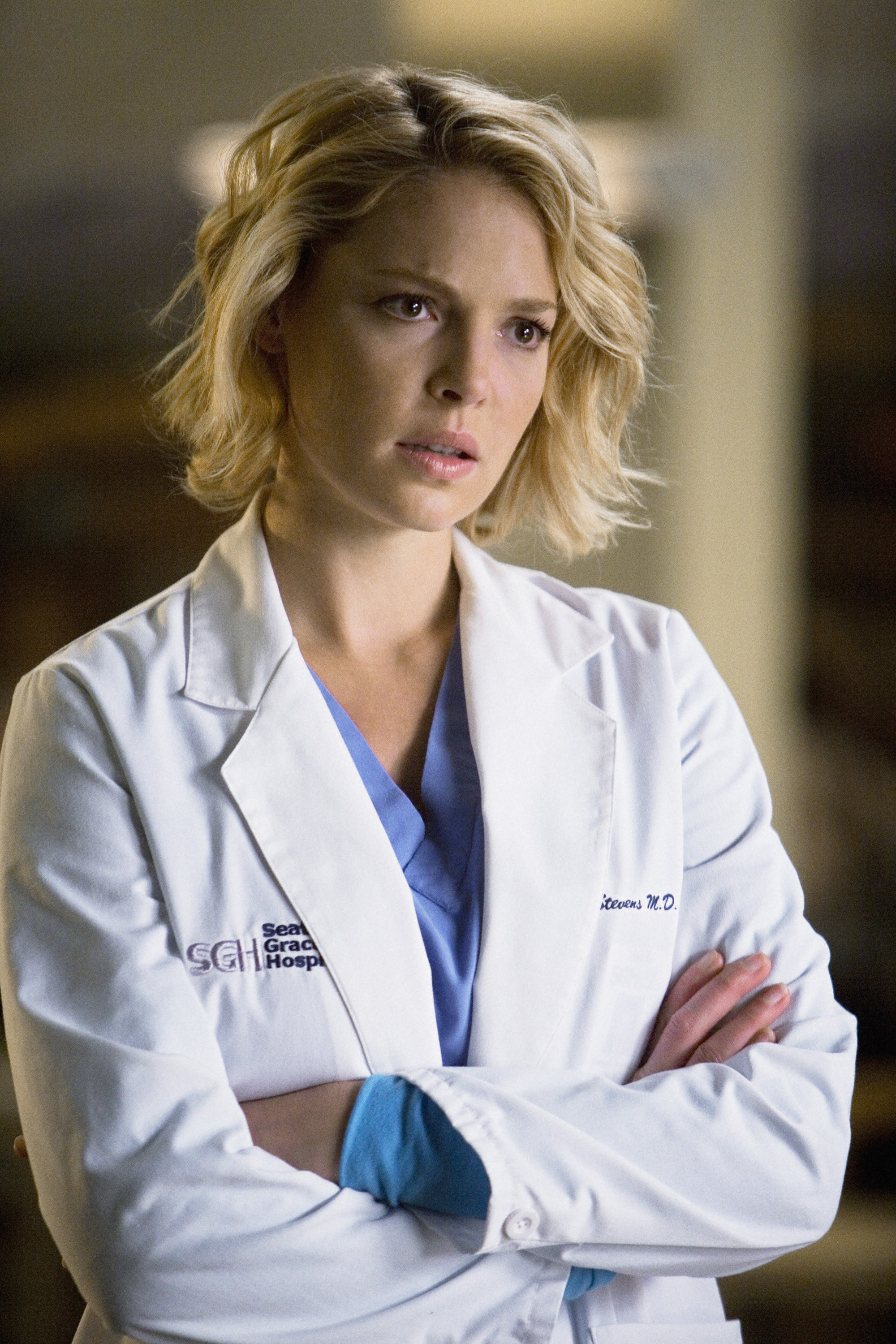 Heigl looks distressed with her arms crossed while wearing a doctor&#x27;s coat