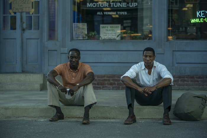 Montrose and Atticus sitting next to one another on a curb