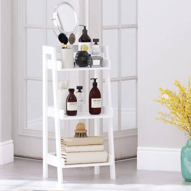 White ladder shelf holding bathroom products.