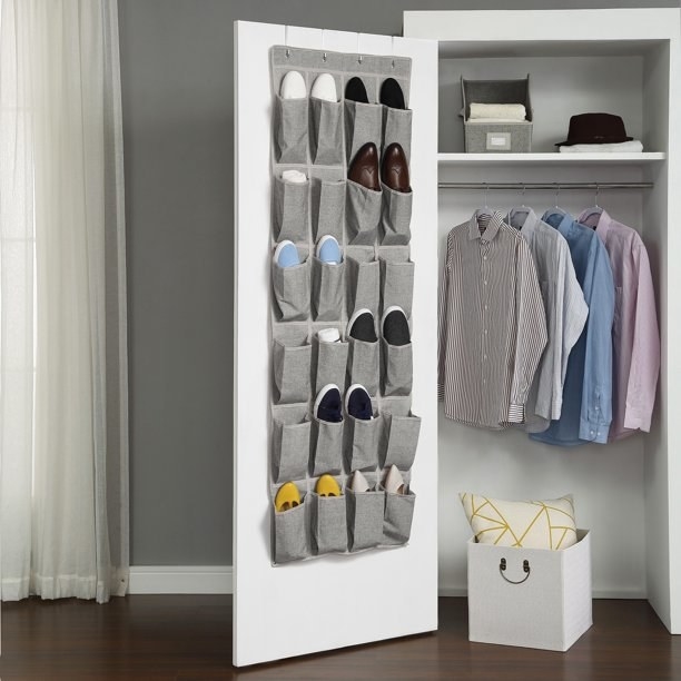Gray shoe organizer hanging on the inside of a closet door.