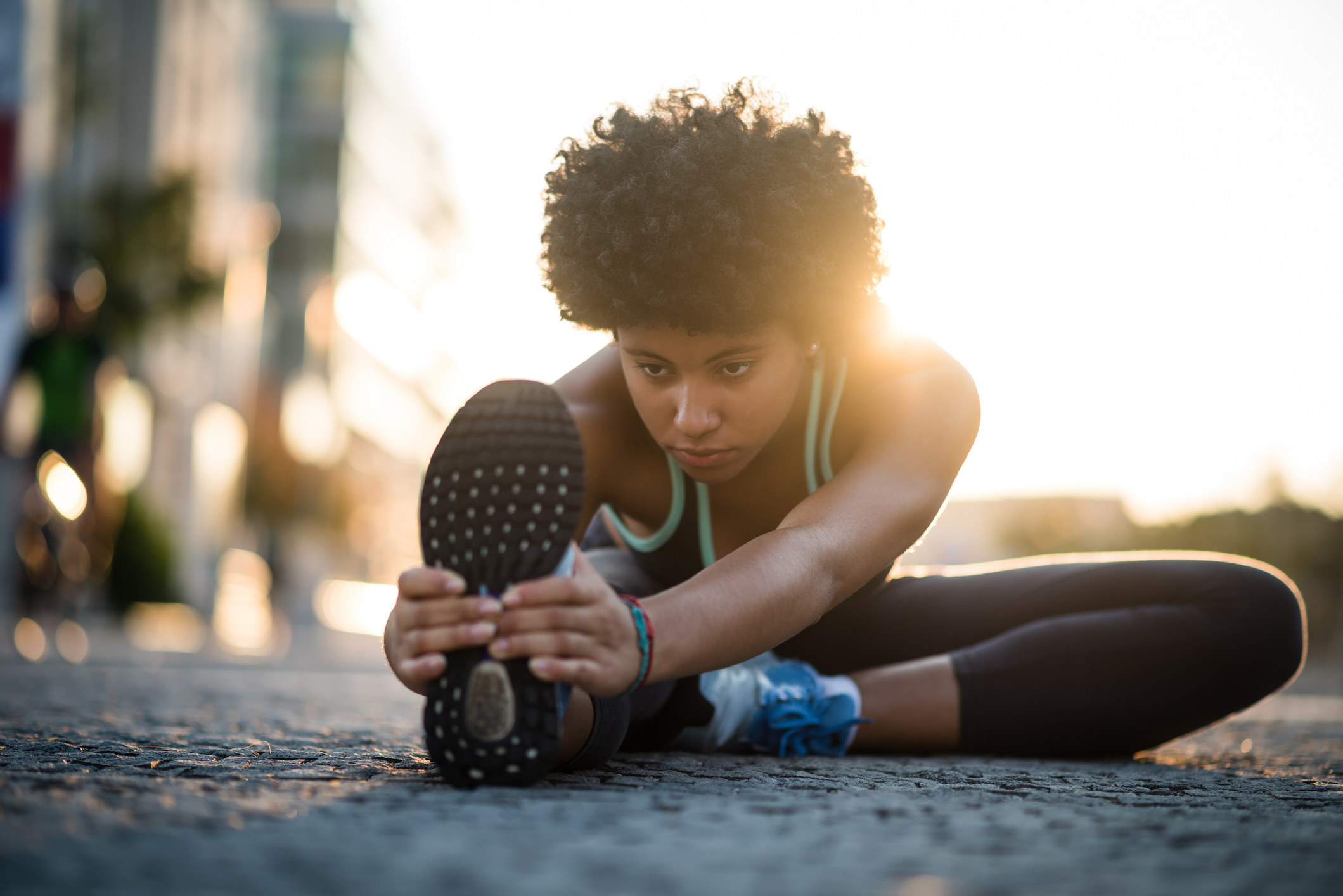 Young woman stretching before running outdoors