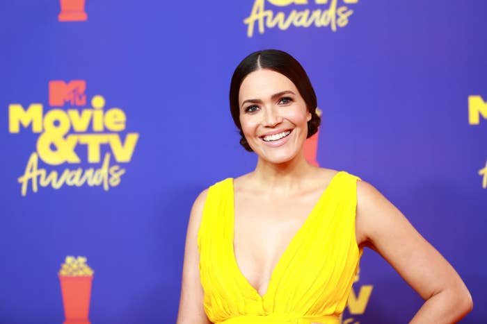 Mandy Moore smiling in a deep-V top on the red carpet