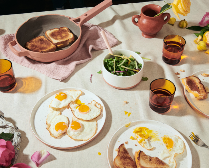an always pan with grilled cheeses in it on the table next to plates of eggs
