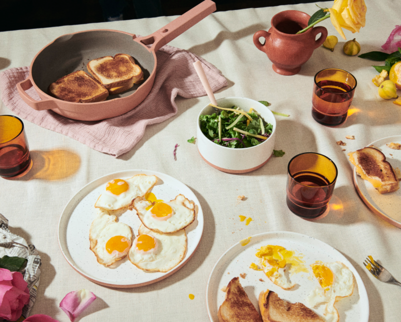 an always pan with grilled cheeses in it on the table next to plates of eggs