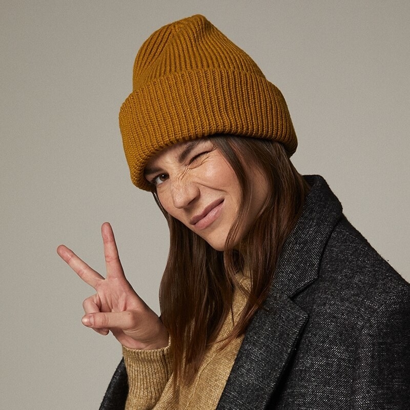 A person wearing a beanie, sweater, and jacket