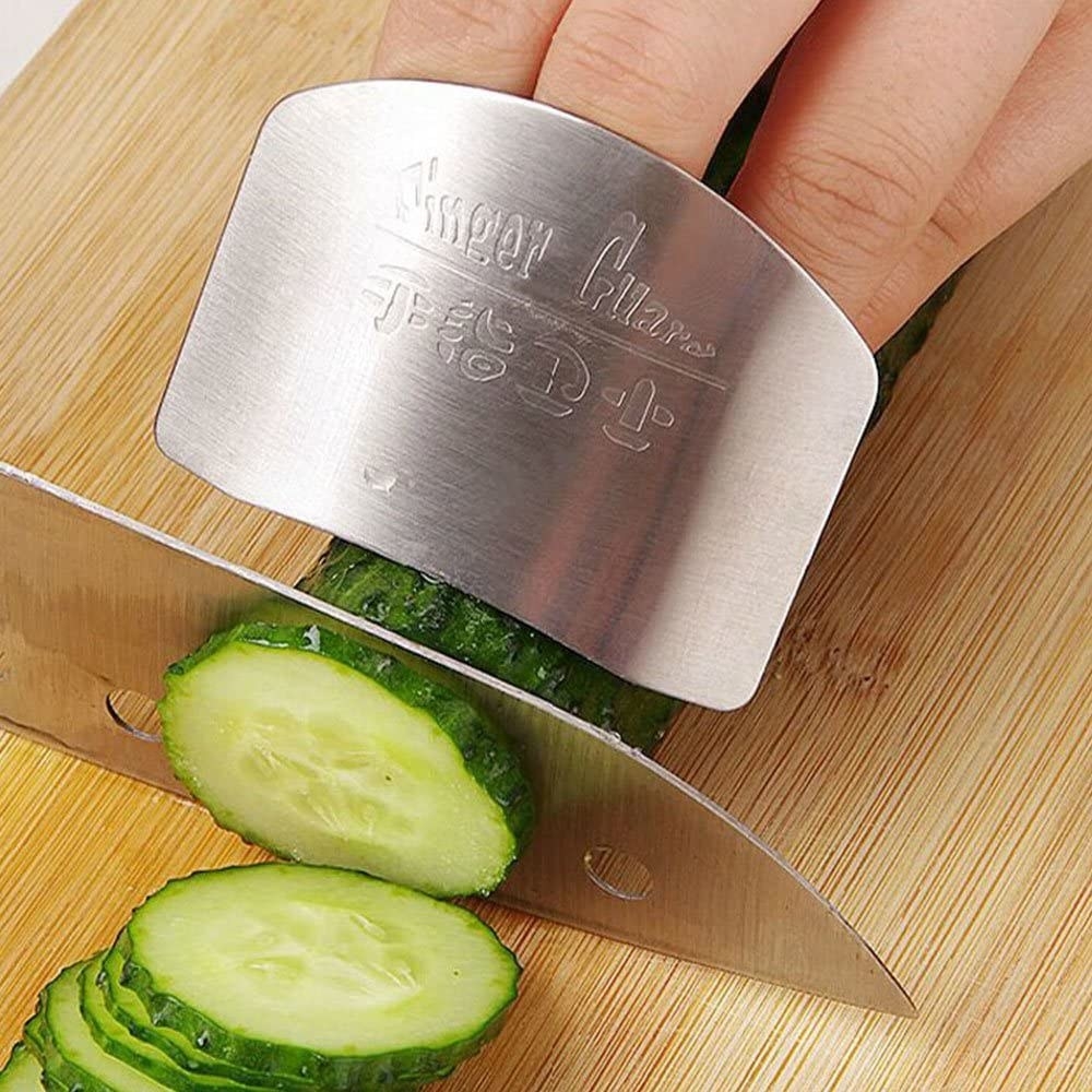 Someone using the finger guard while slicing a cucumber