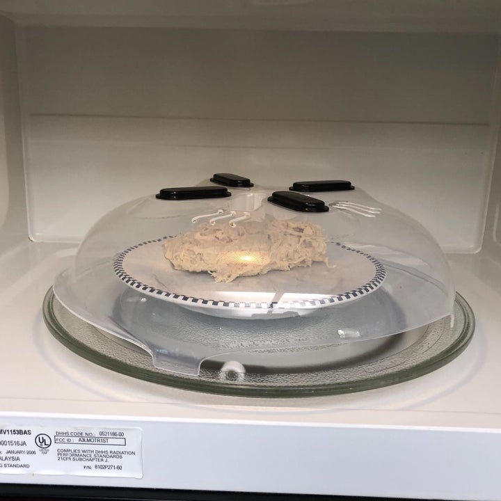 a reviewer photo of the cover over a plate in the microwave 