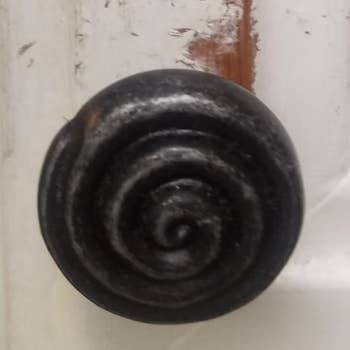 cabinet knob with paint chipped around edges 