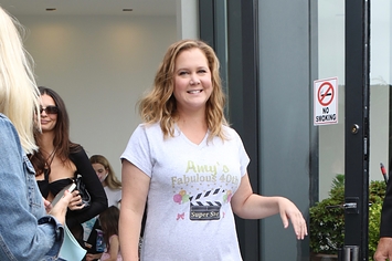 Amy Schumer walks through a doorway with Emily Ratajowski right behind her