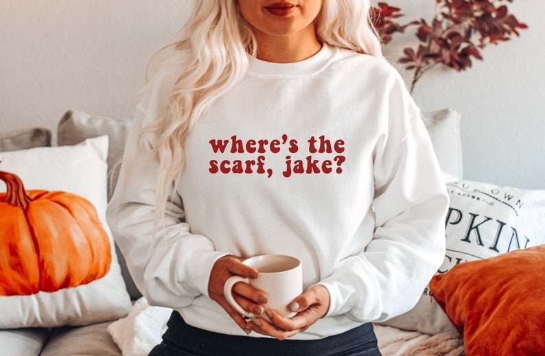 model in crewneck pullover reading &quot;Where&#x27;s the scarf, jake?&quot; in red text