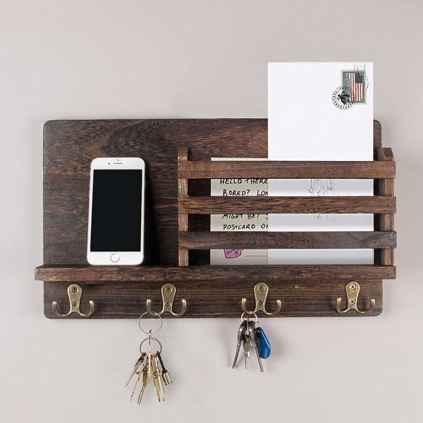 Wood shelf with hooks, shown holding mail, a phone and two sets of keys.