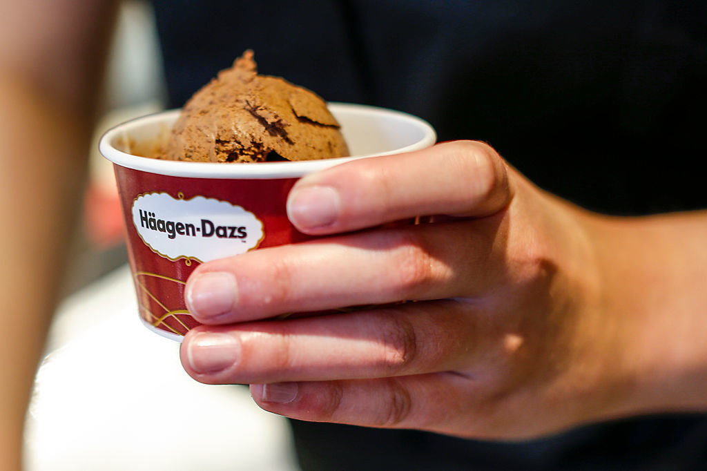 handing someone a cup of chocolate haagen dazs ice cream