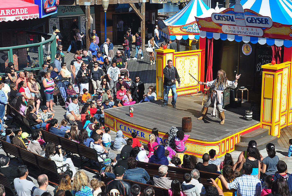 a huge crowd watching a pirate show on the pier