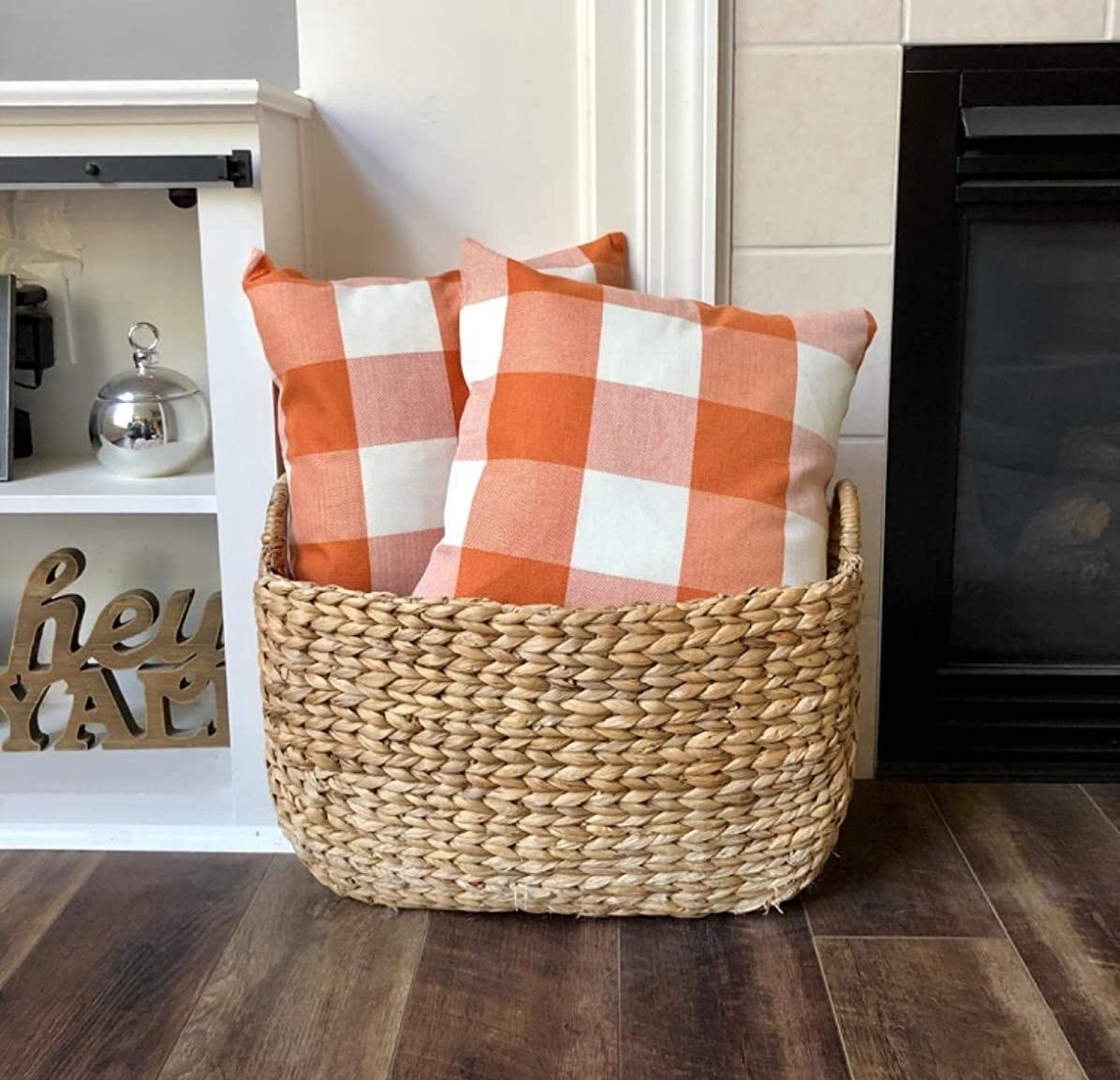 Reviewer&#x27;s orange and white plaid pillows are shown in a basket