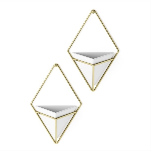 the two diamond-shaped hangers with gold rims and a white basket