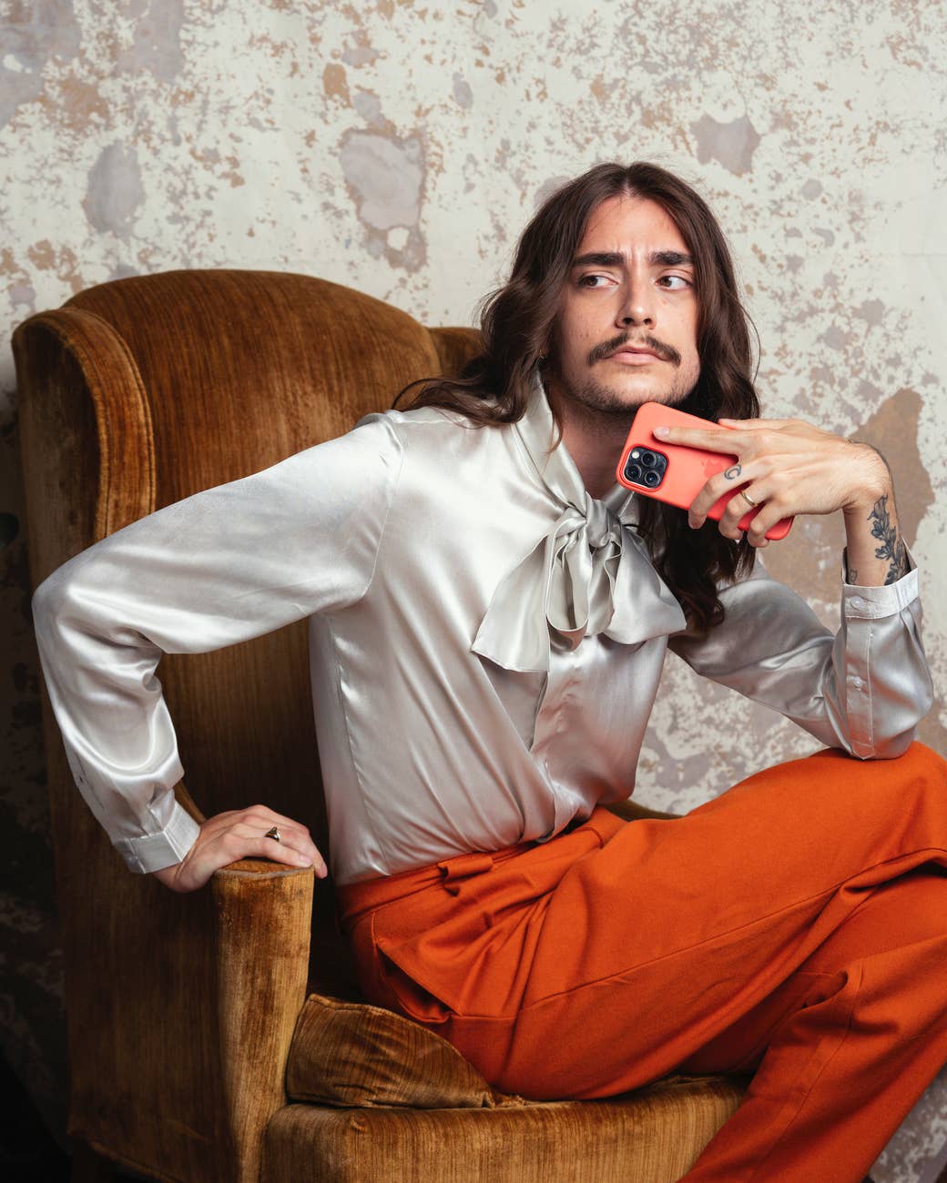 Tyler Gaca on a chair at home with his phone, looking off camera