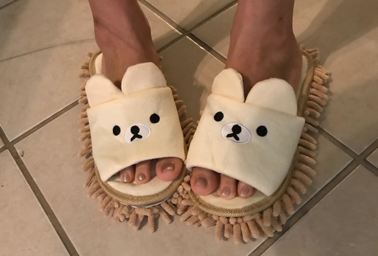 a reviewer wearing a pair of teddy bear mop slippers