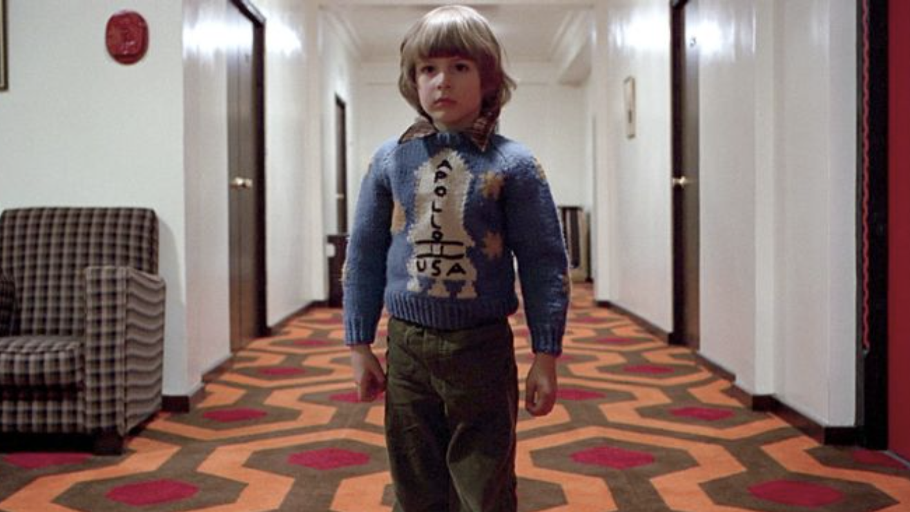 Danny walks down the iconic hallway in The Shining wearing a NASA spaceship sweater