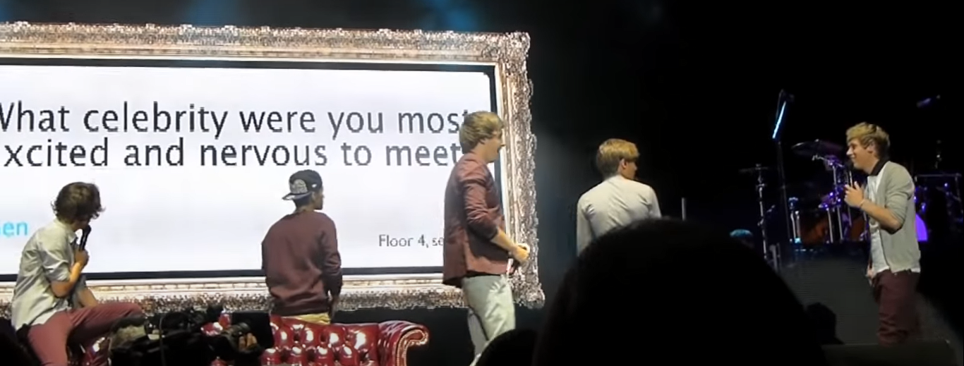 A boyband on stand answering questions