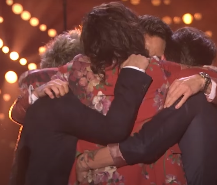 A bunch of men group hugging