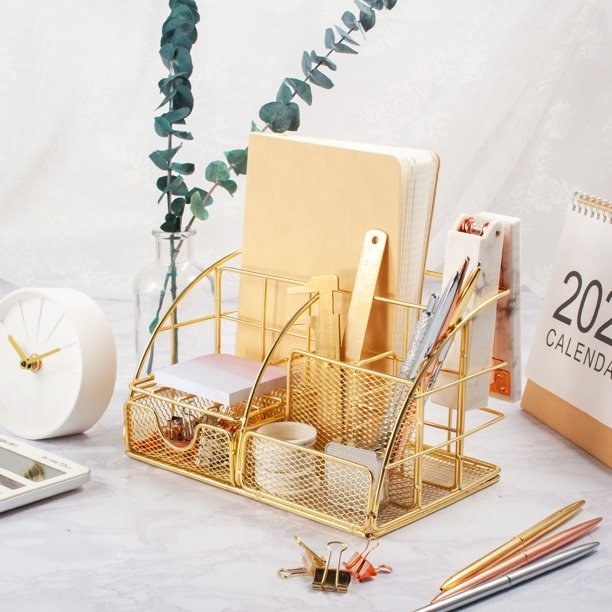 Gold desk organizer holding various stationery supplies.