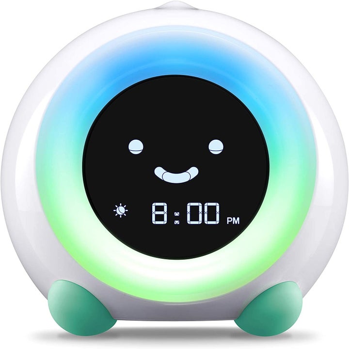 The clock glowing green and teal with a smiley face