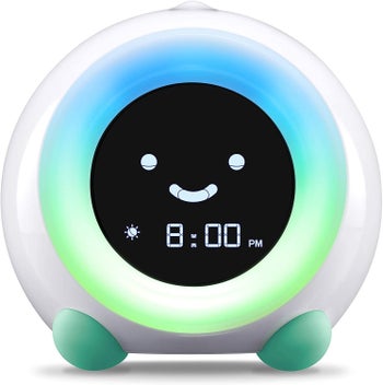 The clock glowing green and teal with a smiley face