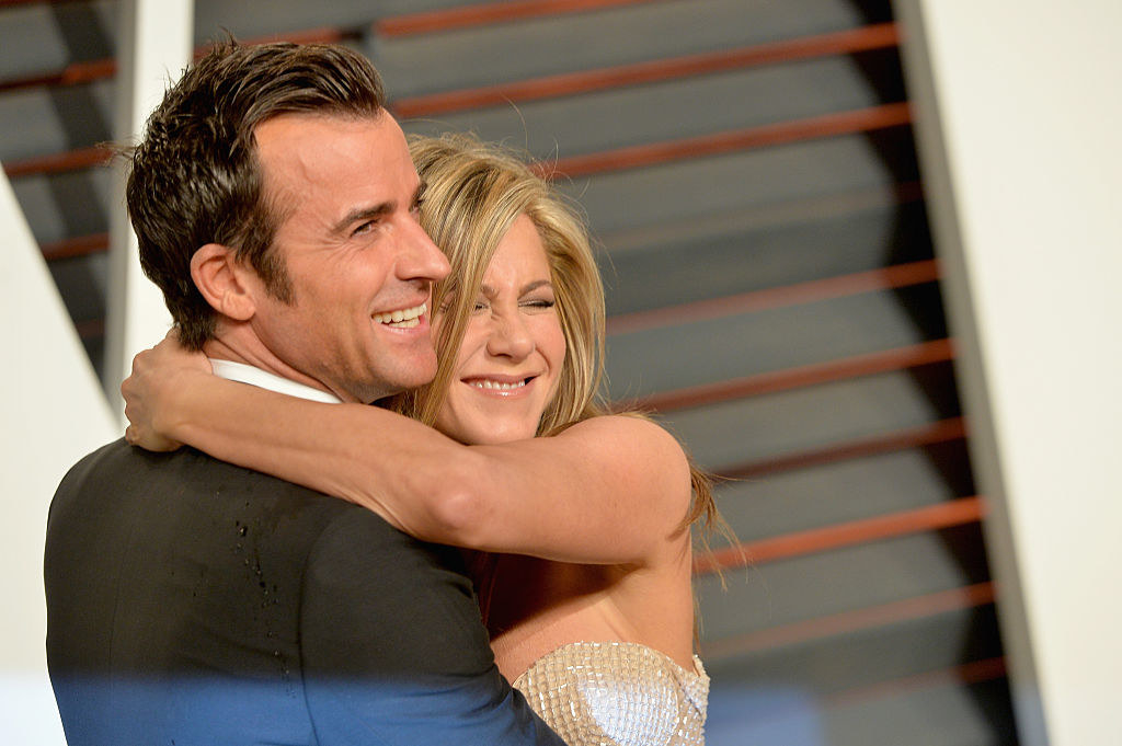 Justin Theroux (L) and Jennifer Aniston hugging at the 2015 Vanity Fair Oscar Party