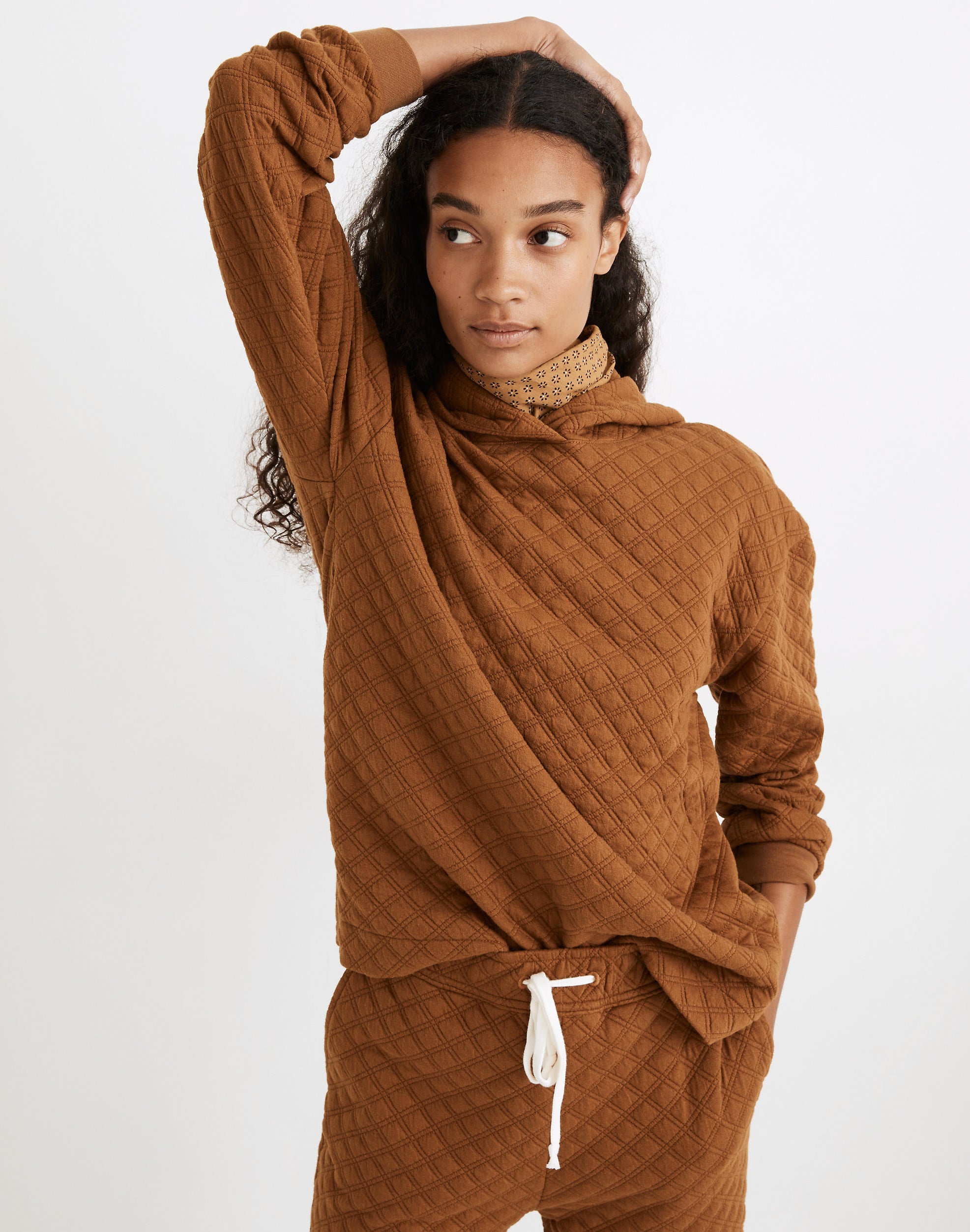 a model in a quilted dark orange sweatshirt